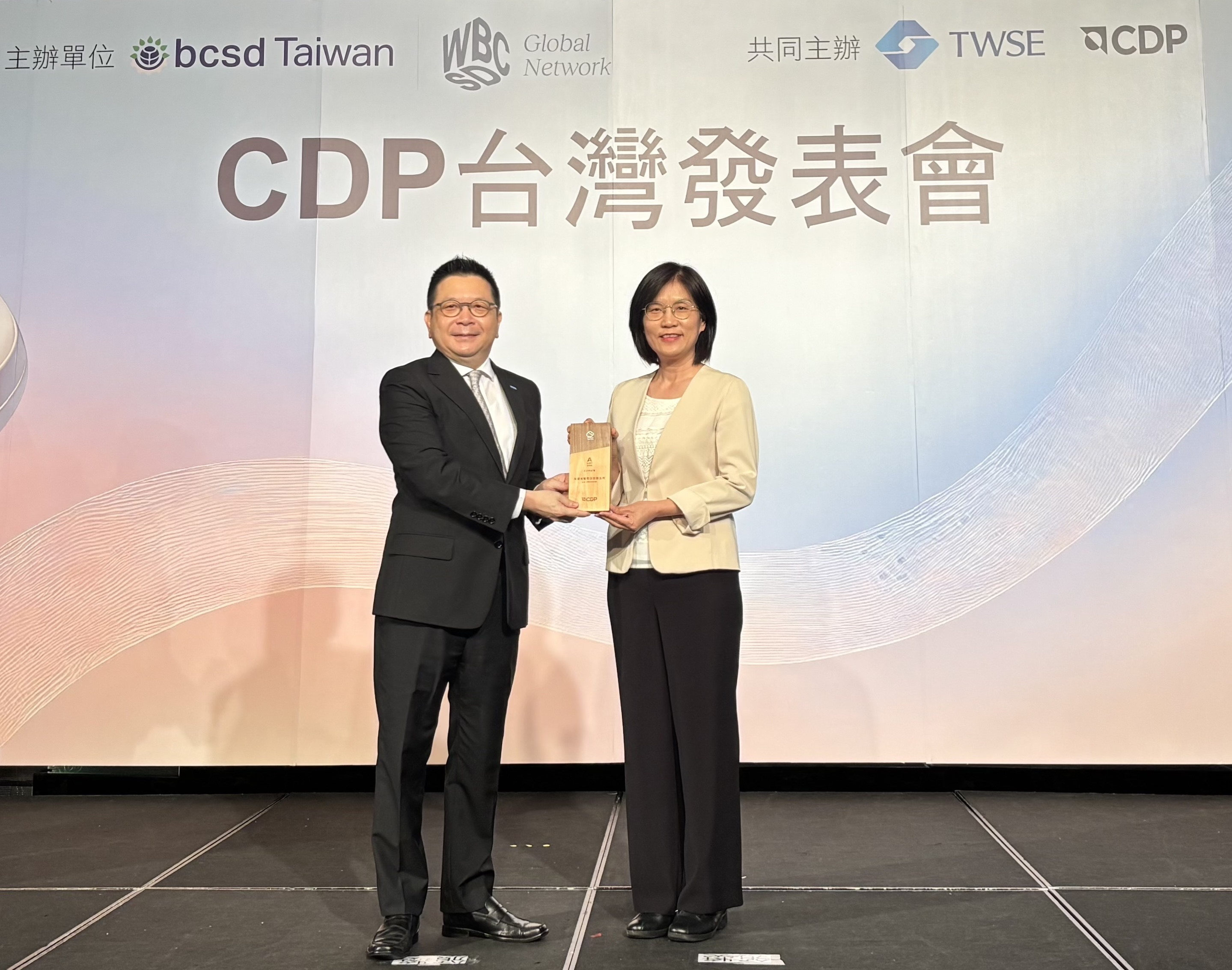 友達永續成果再獲國際評比肯定，獲頒CDP氣候與水資源雙項領導力評級。今由臺灣證券交易所董事長林修銘（左）頒獎，友達光電永續長古秀華（右）代表受獎